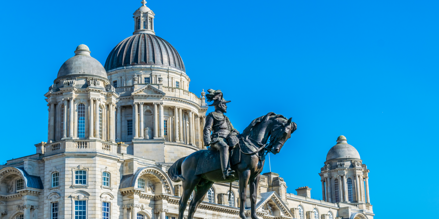 Statue of a man on horseback in front of a building.