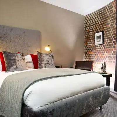 Bedroom featuring a brick wall and a bed.