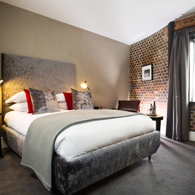 Bedroom featuring a brick wall and a bed.