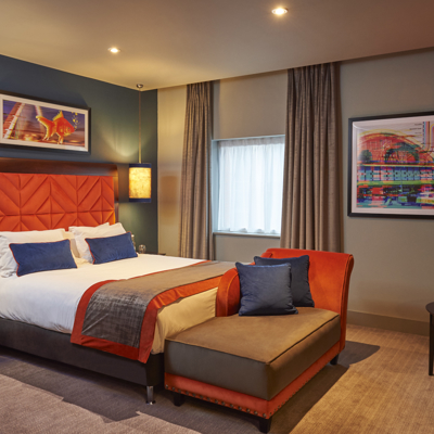 An elegantly furnished hotel room featuring a comfortable bed and a stylish chair.