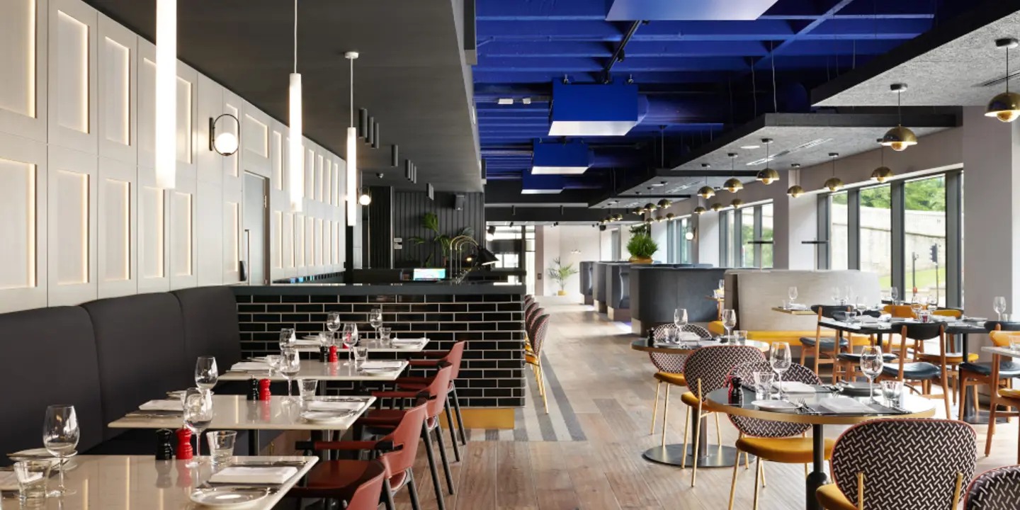 A restaurant featuring tables, chairs, and a blue ceiling.