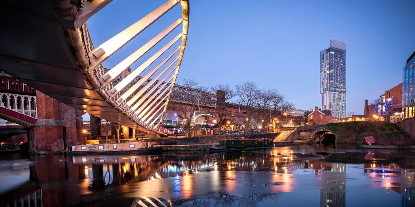 A bridge spanning a river with buildings in the background.