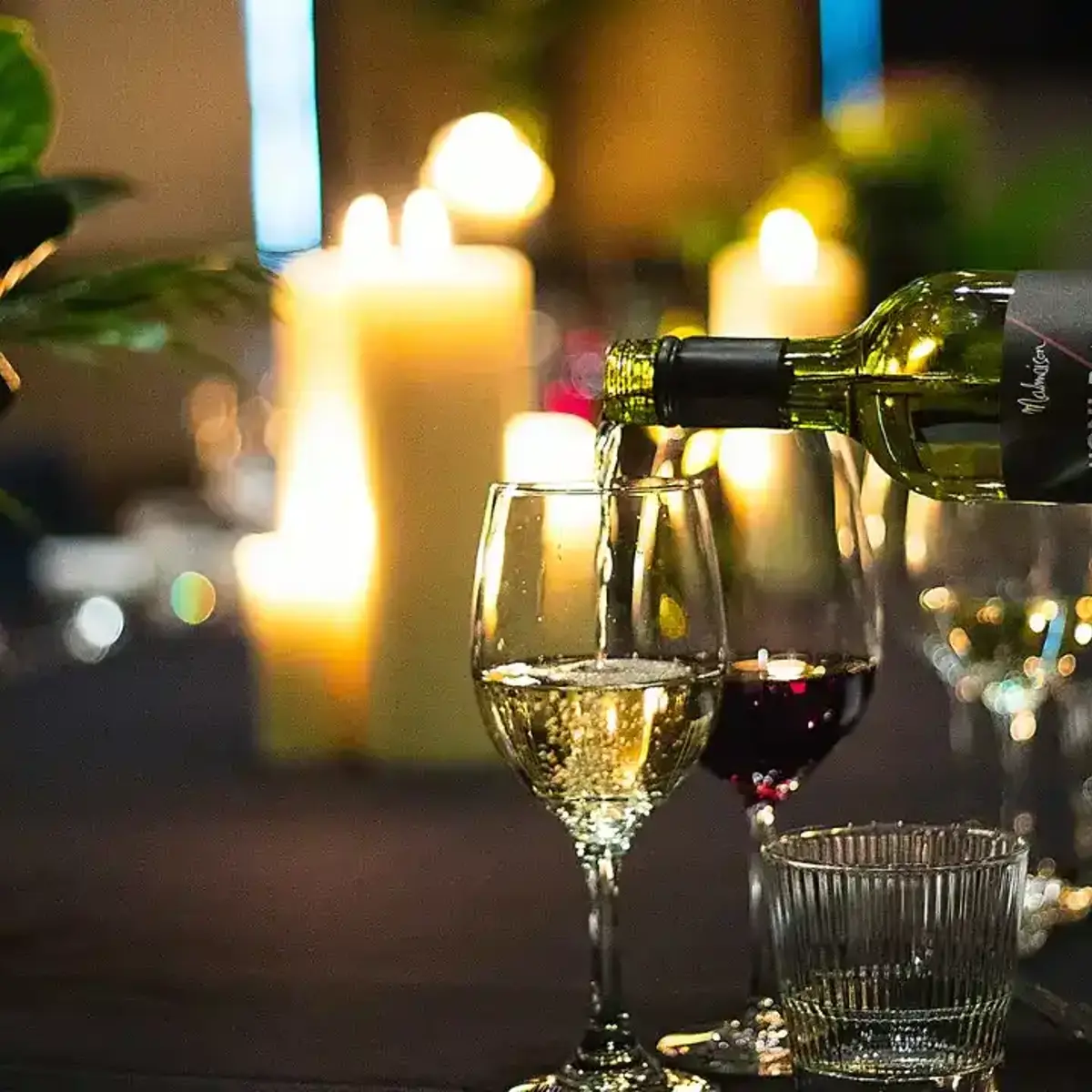 A person pouring wine into a glass.