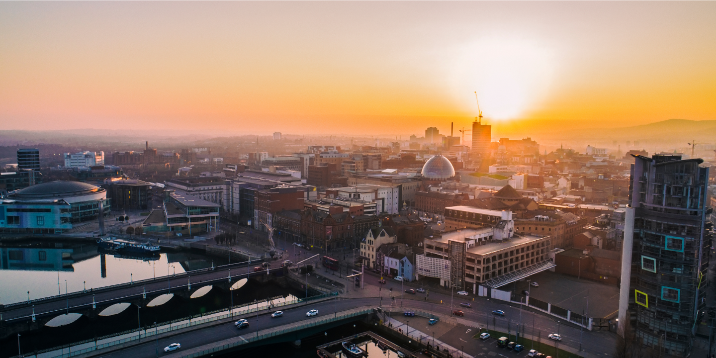 Sunset over a city skyline with boats in the water.