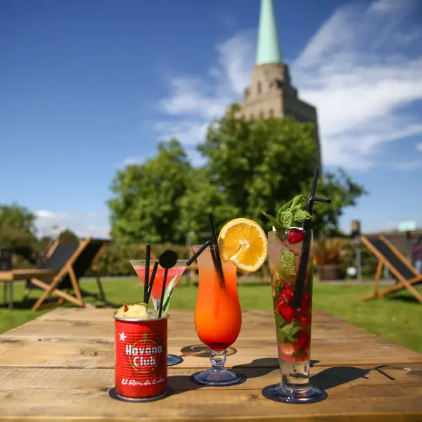 Two glasses filled with drinks placed on a wooden table.
