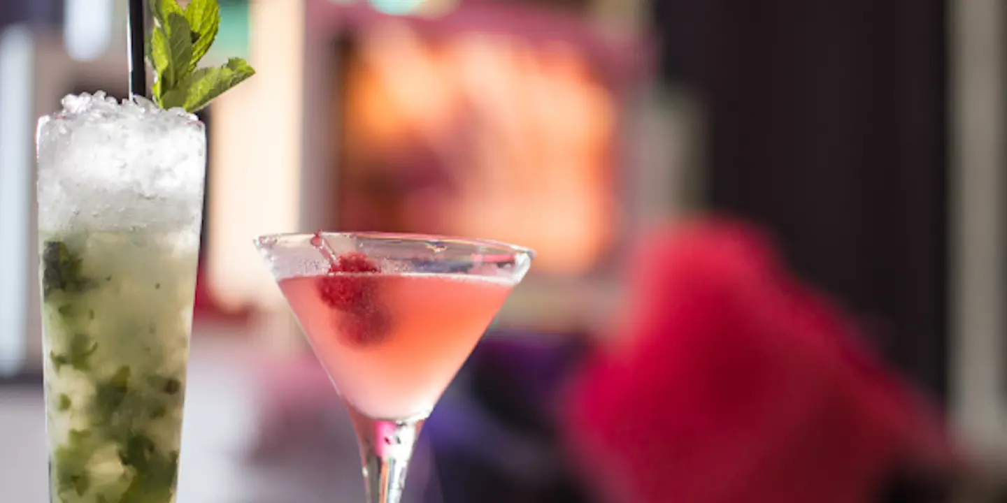 Two cocktails placed on a table.