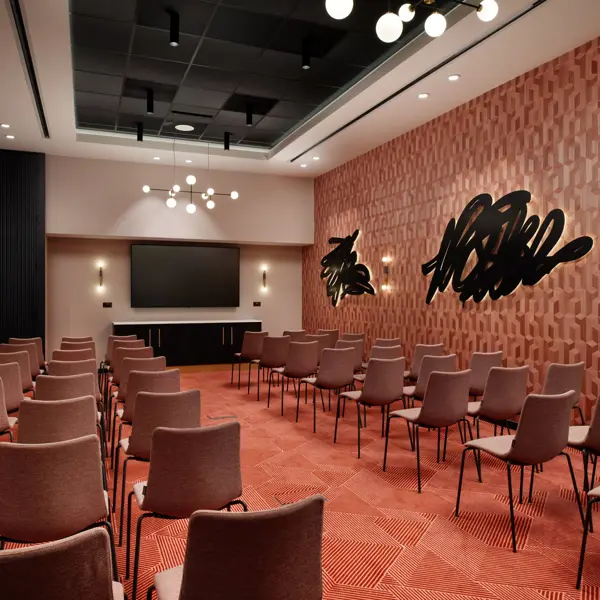 Conference room featuring chairs and a projector screen.