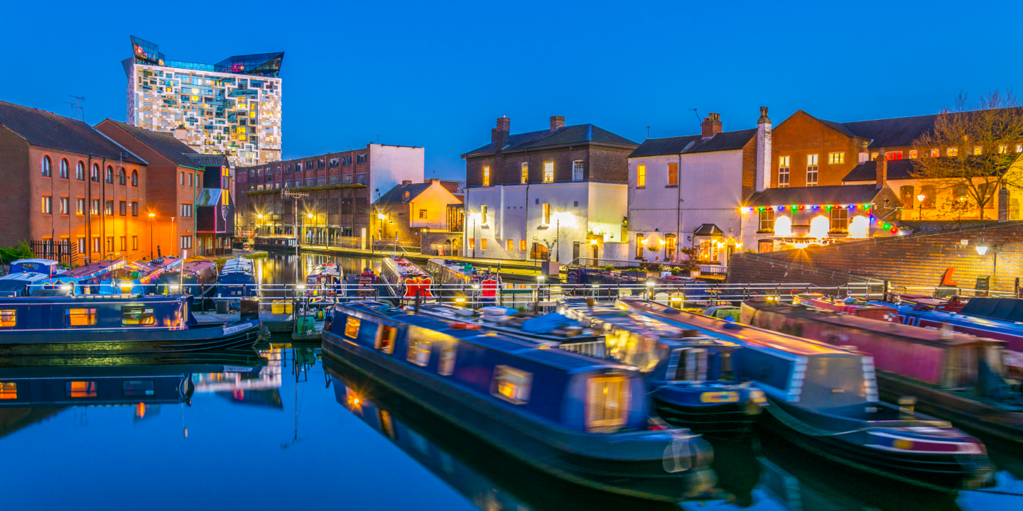 Narrow boats lit by street lighting at night.