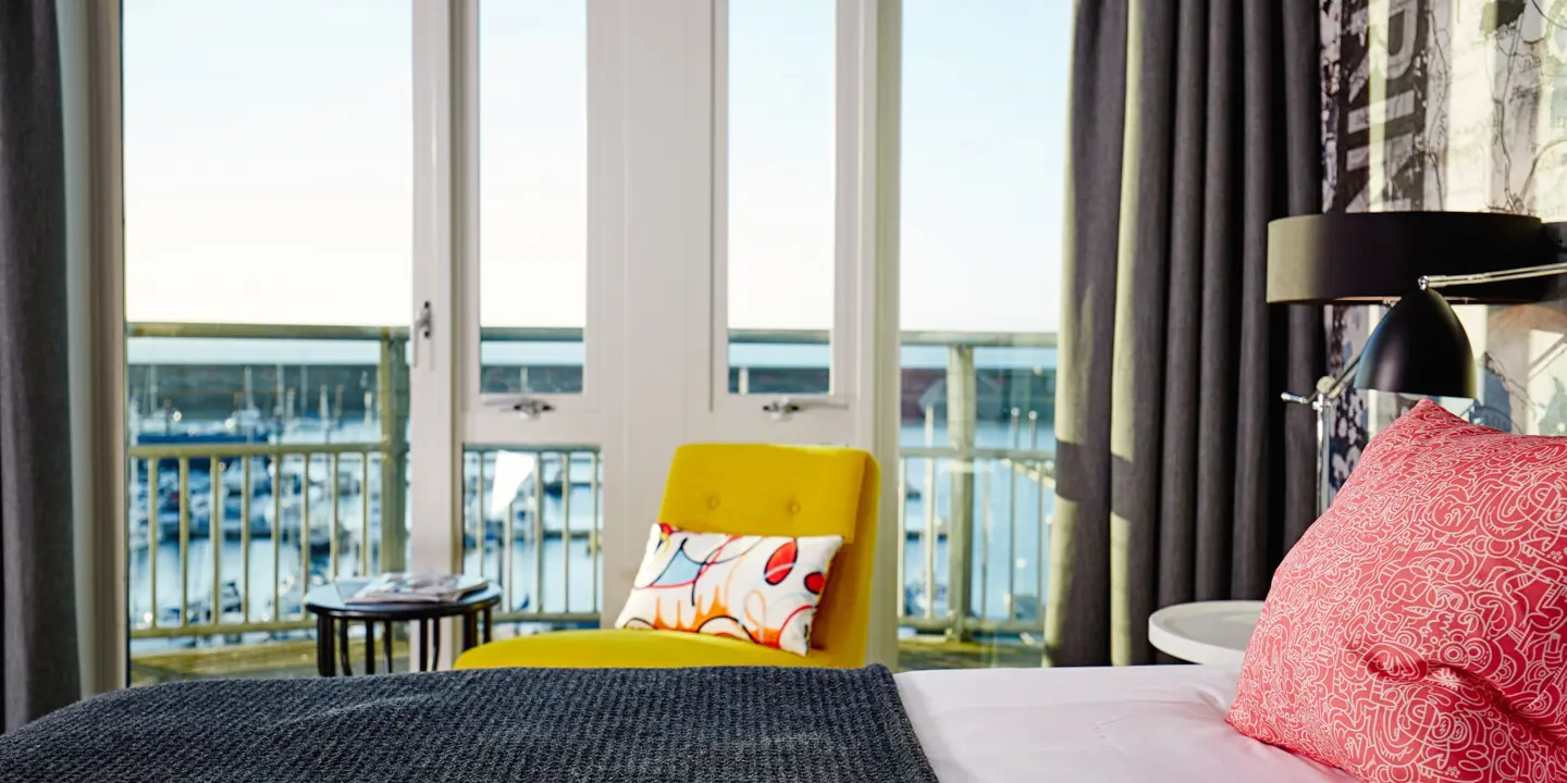 Bedroom featuring a comfortable bed and chair positioned in front of a window.