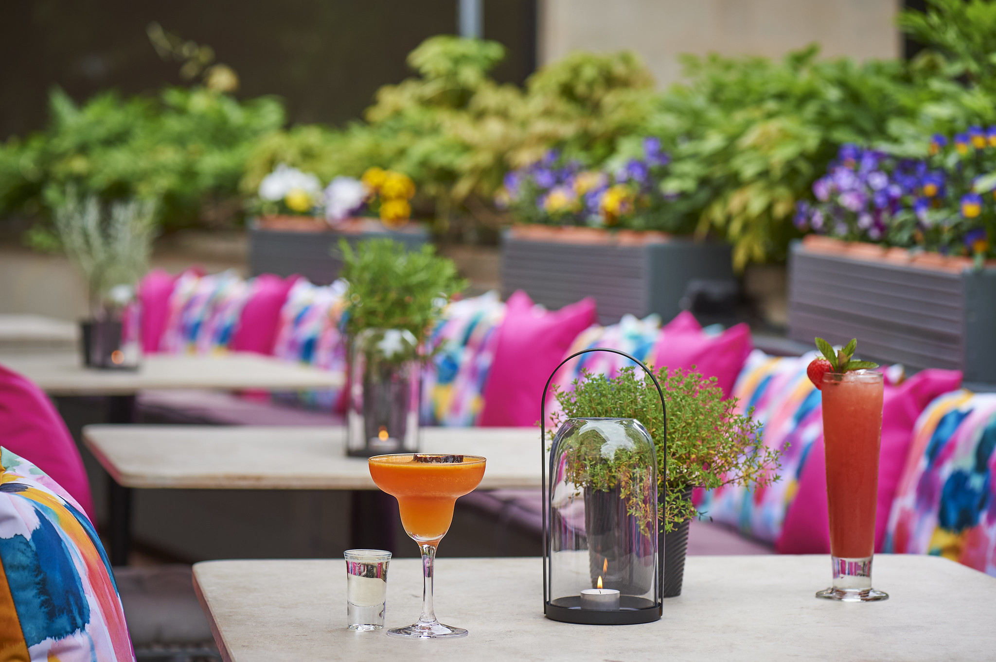 A table featuring two glasses of wine and a vase filled with flowers.