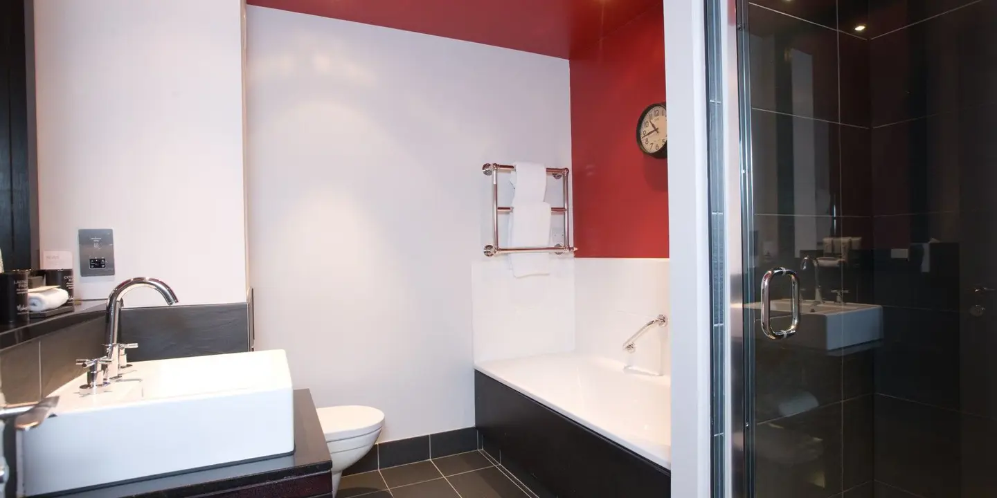 Bathroom featuring a toilet, sink, and shower.