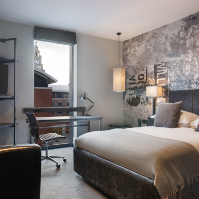 Spacious bedroom featuring a king-sized bed and a functional desk.