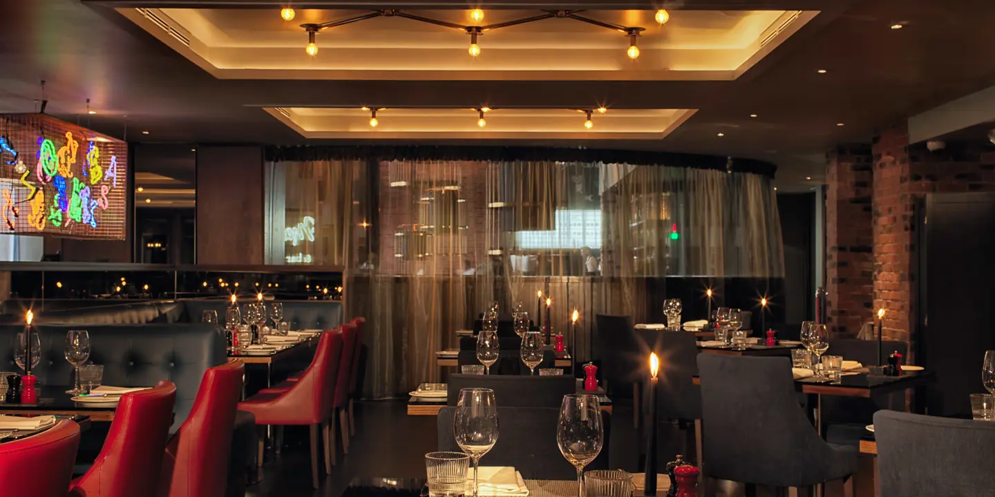 A candle lit dining hall with a mixture of black and red decor