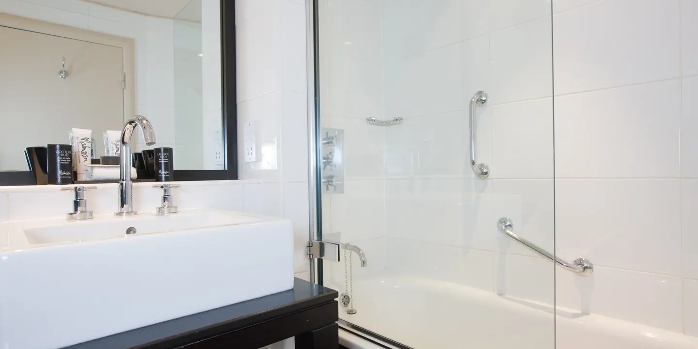 Bathroom featuring a sink, shower, and mirror.