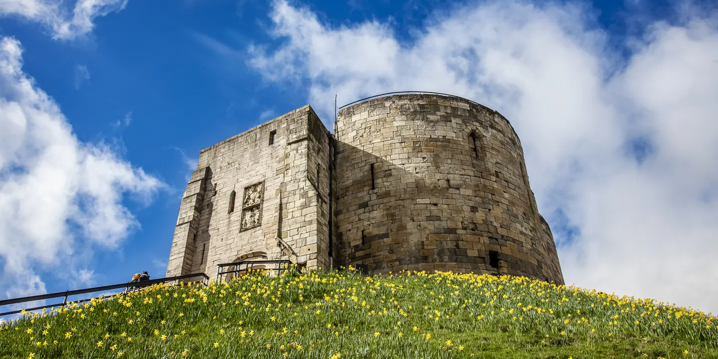 A majestic stone tower perched atop a verdant hillside.