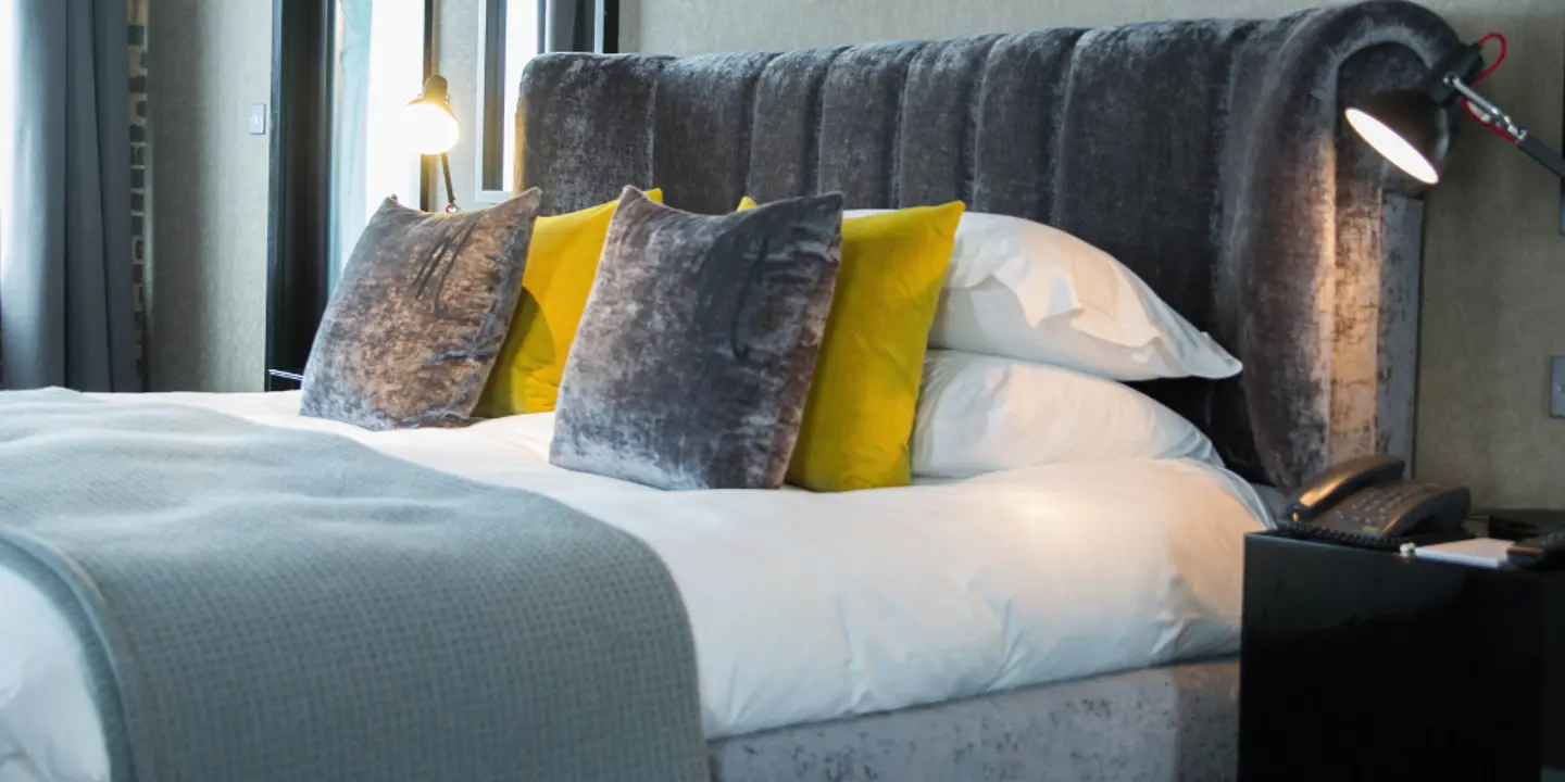 A spacious bedroom featuring a king-sized bed and an art piece adorning the wall.