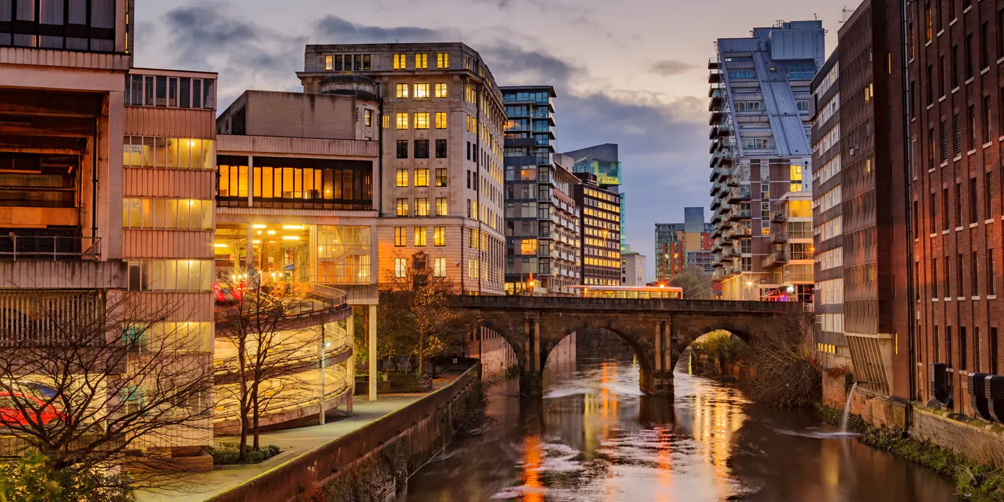  River flowing through urban landscape with towering buildings.