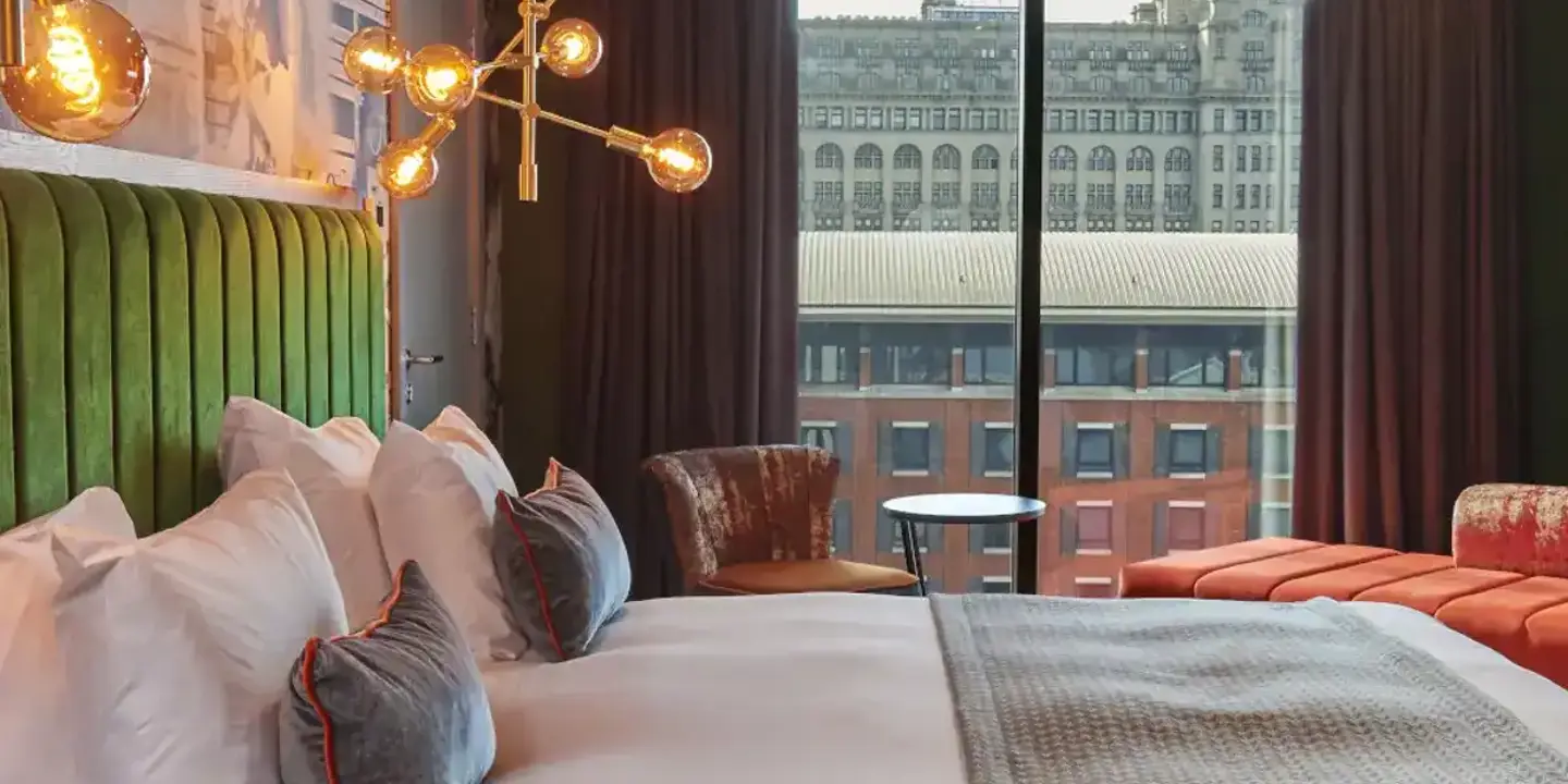 Spacious hotel room featuring a king-sized bed and panoramic city view.