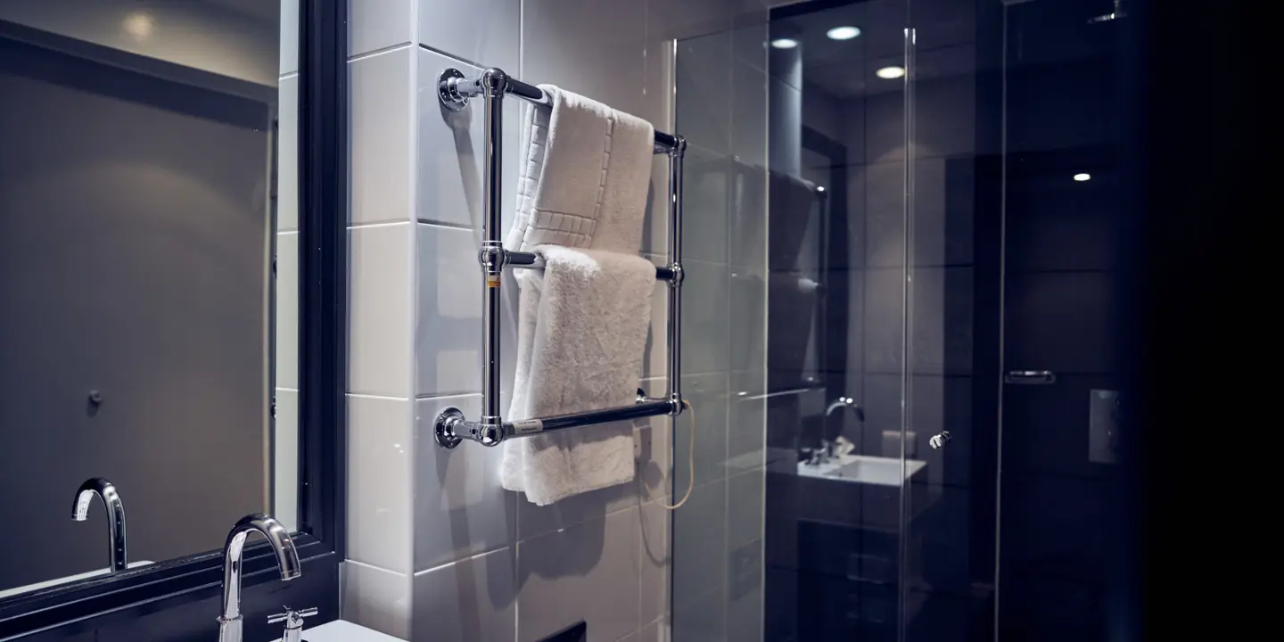 Bathroom featuring a sink, shower and towel rail.