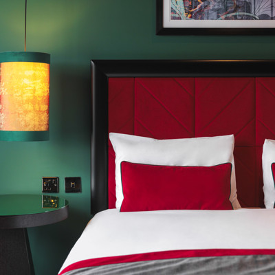 A comfortable bed and a stylish bed side table and light.