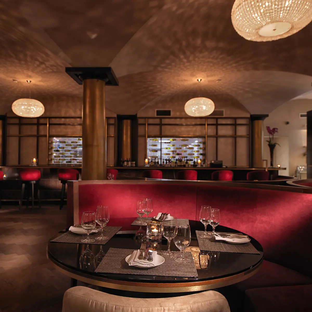A restaurant featuring red booths, tables, and chairs.
