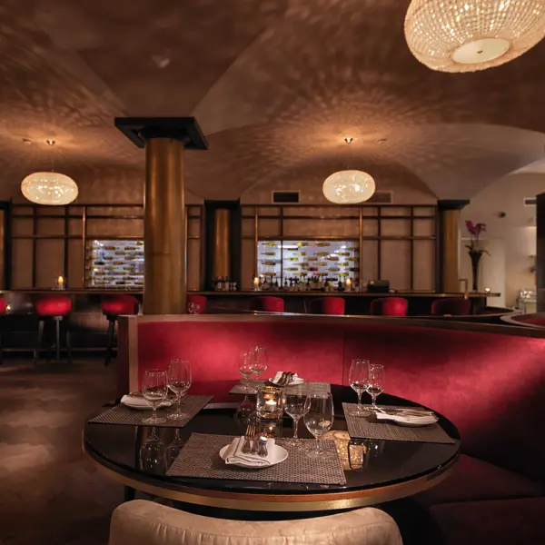 A restaurant featuring red booths, tables, and chairs.