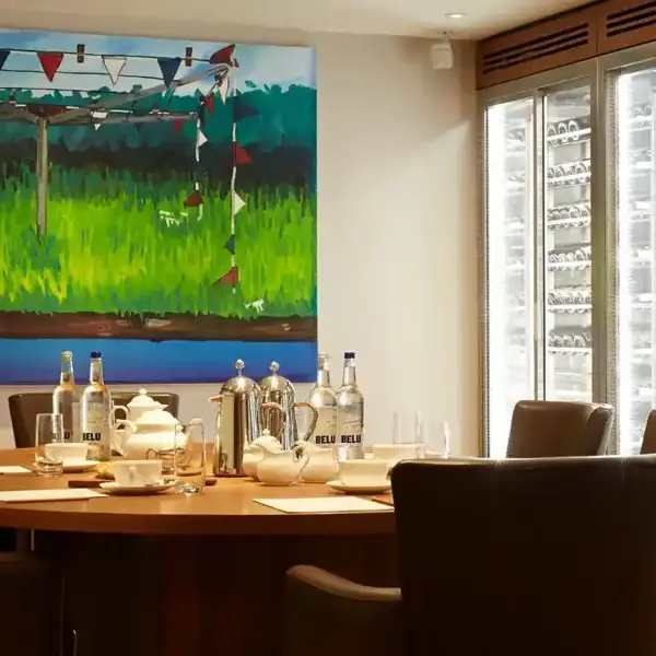 Dining room table with chairs and a painting on the wall