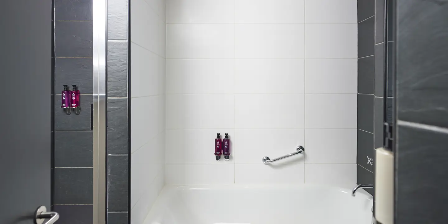 White bathtub positioned alongside a shower.