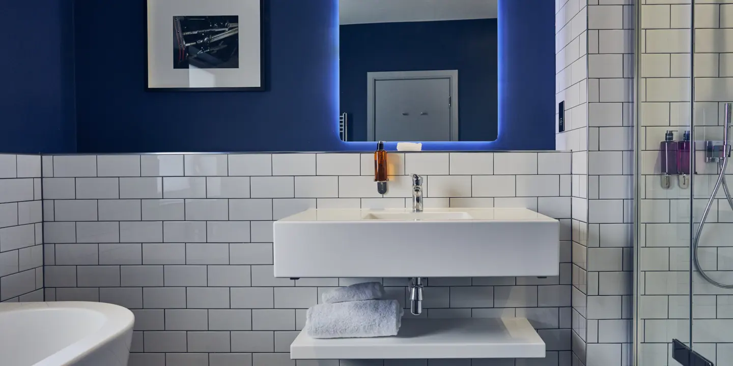 A bathroom featuring a sink, mirror, and bathtub.