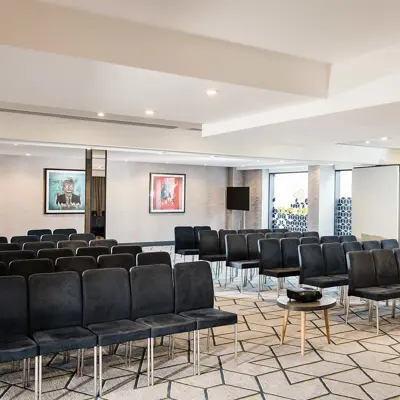 An interior space adorned with sleek black chairs and tables.