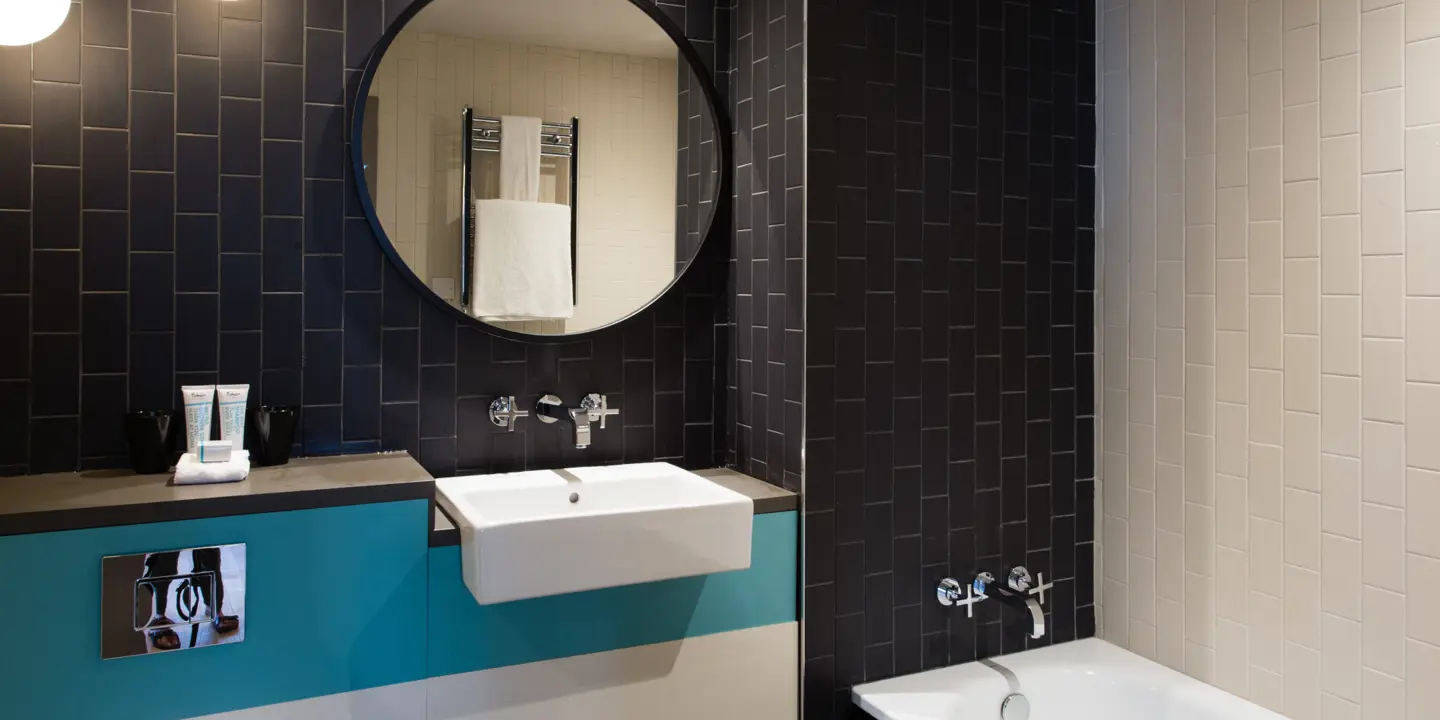 Bathroom featuring a bathtub, sink, and mirror.