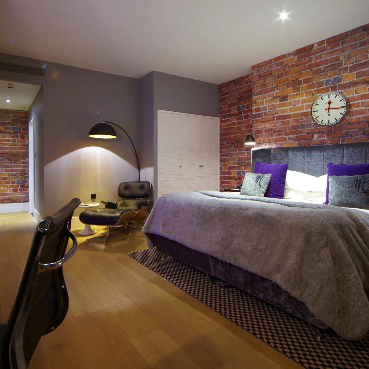 Bedroom featuring a brick wall and a bed.