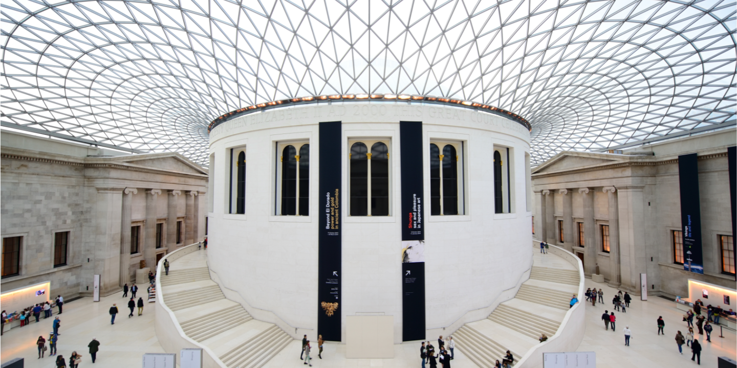 Several individuals strolling around a spacious edifice.