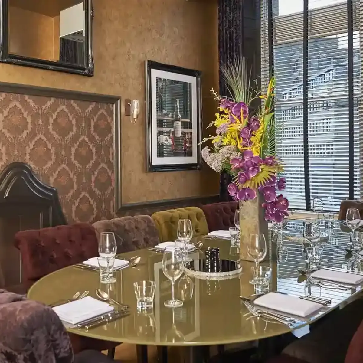 A table arranged for a formal dinner in a dimly lit room.