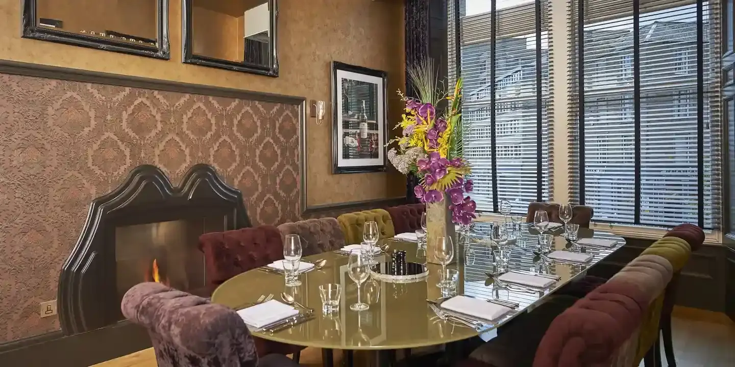 A table arranged for a formal dinner in a dimly lit room.