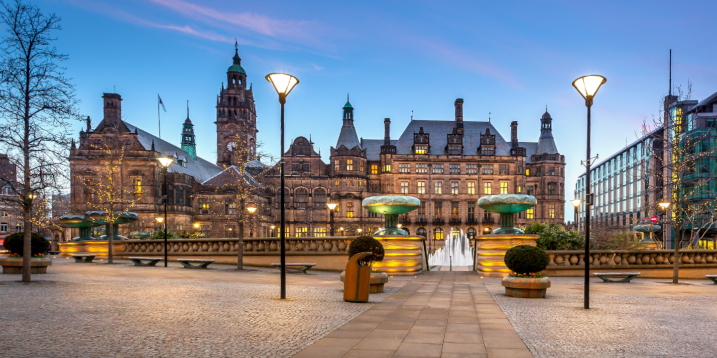 A large building with a fountain in front.