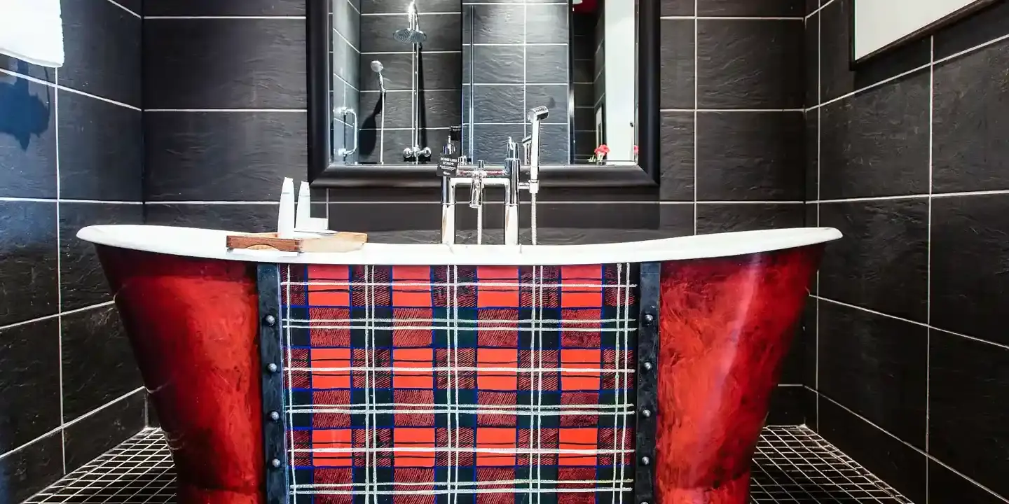 Tartan bathtub beneath a large mirror.