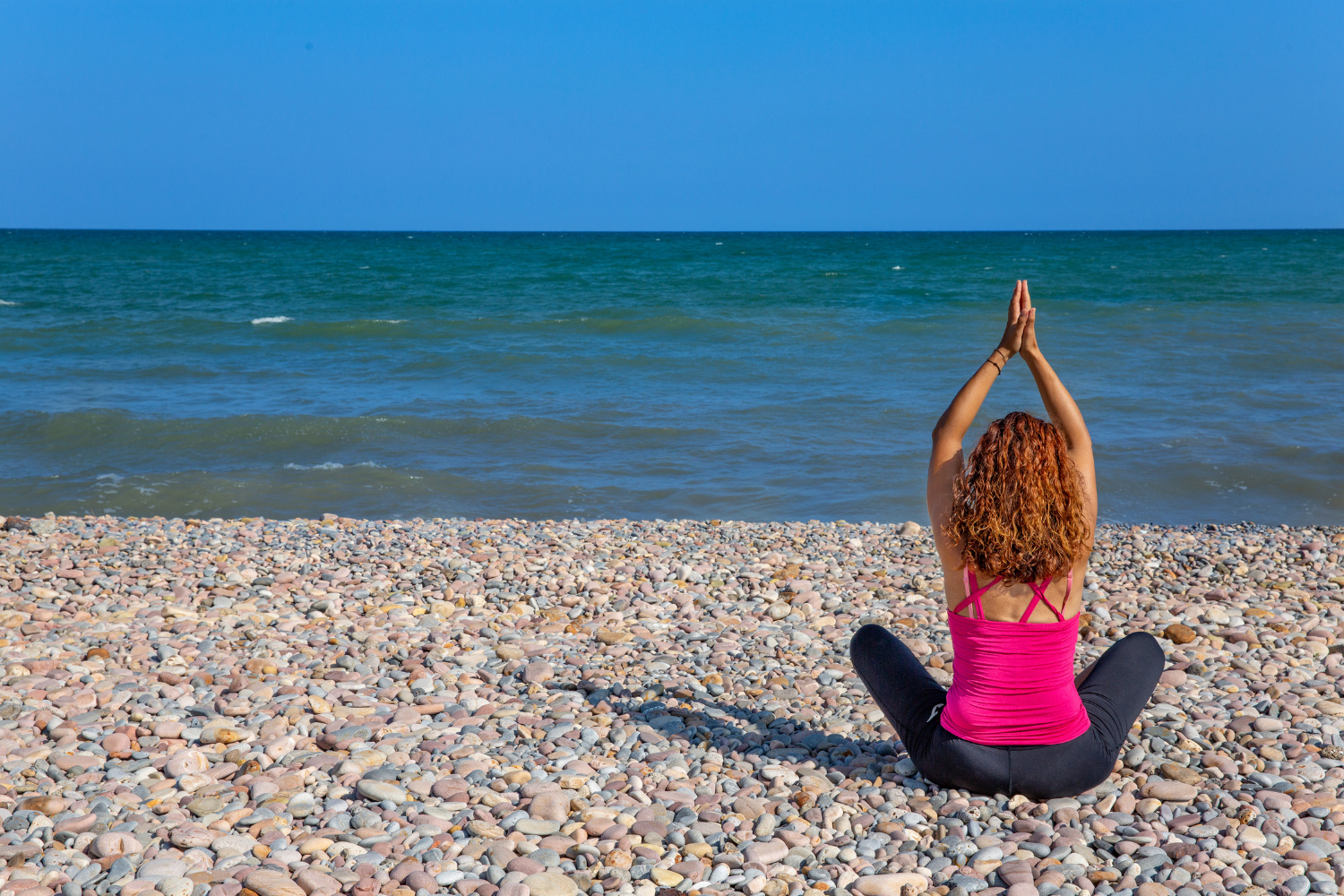 Women doing yoga at the beach
