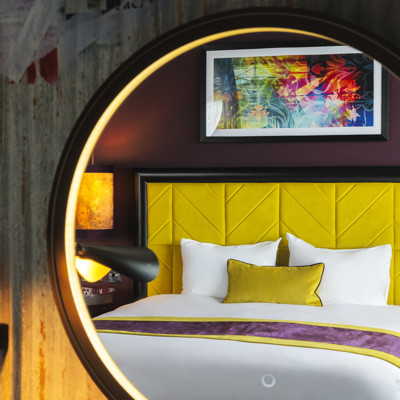 Neatly arranged bedroom with a well-made bed and a lamp.