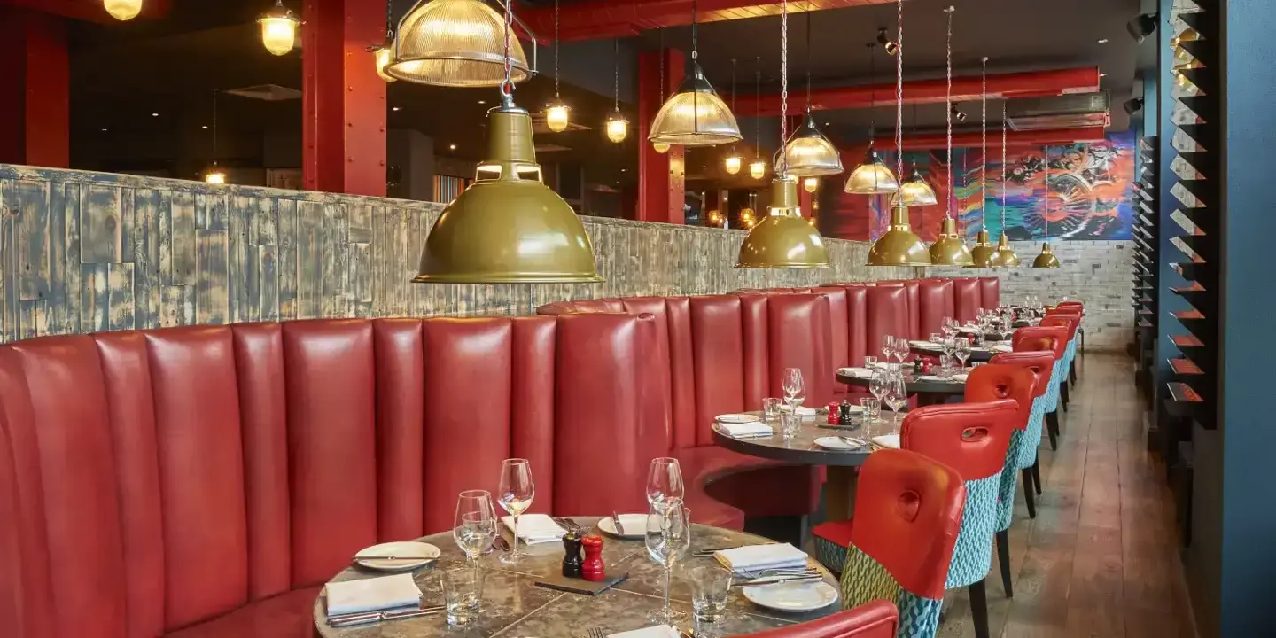 A restaurant featuring red booths and chairs.