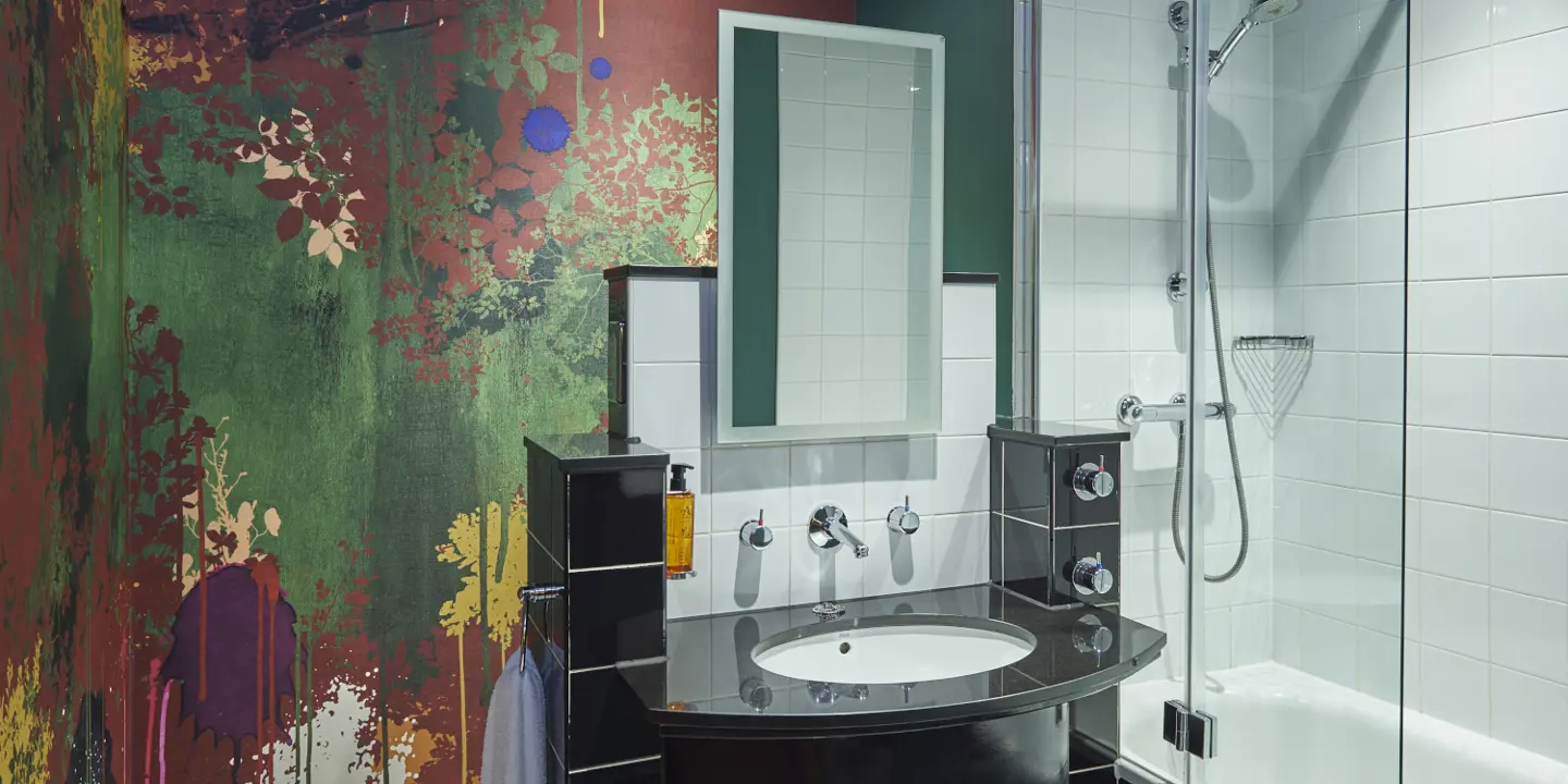 Bathroom featuring a sink, shower, and mirror.