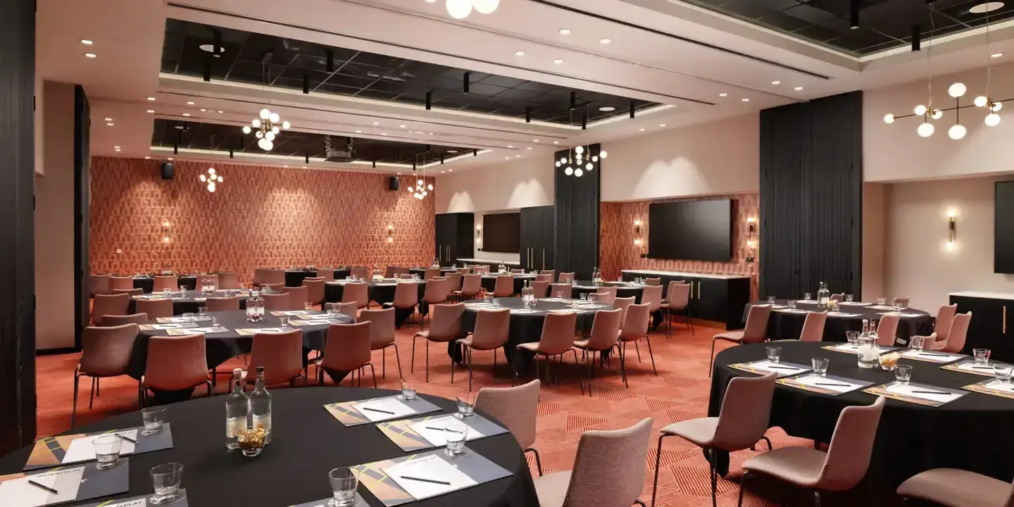 Spacious conference room featuring tables and chairs.