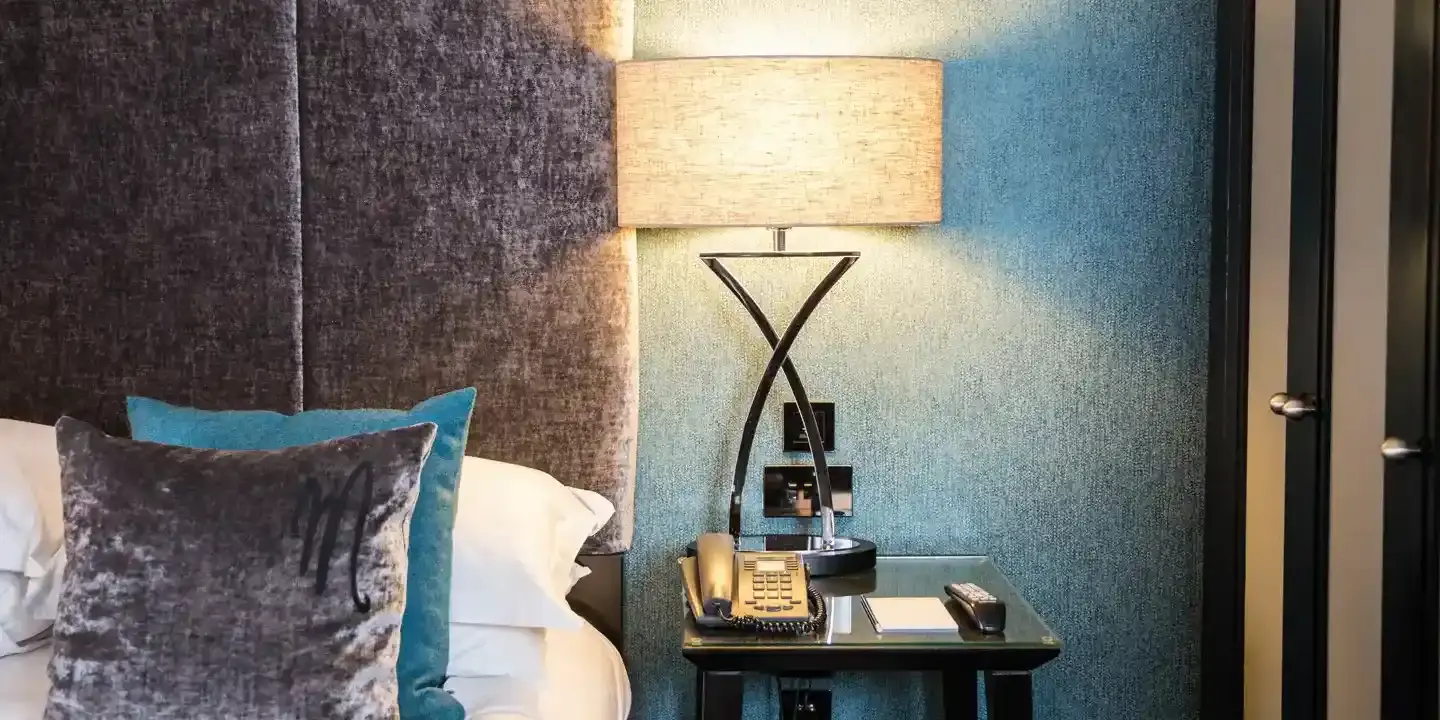 Neatly arranged bedroom with a well-made bed and nightstand.