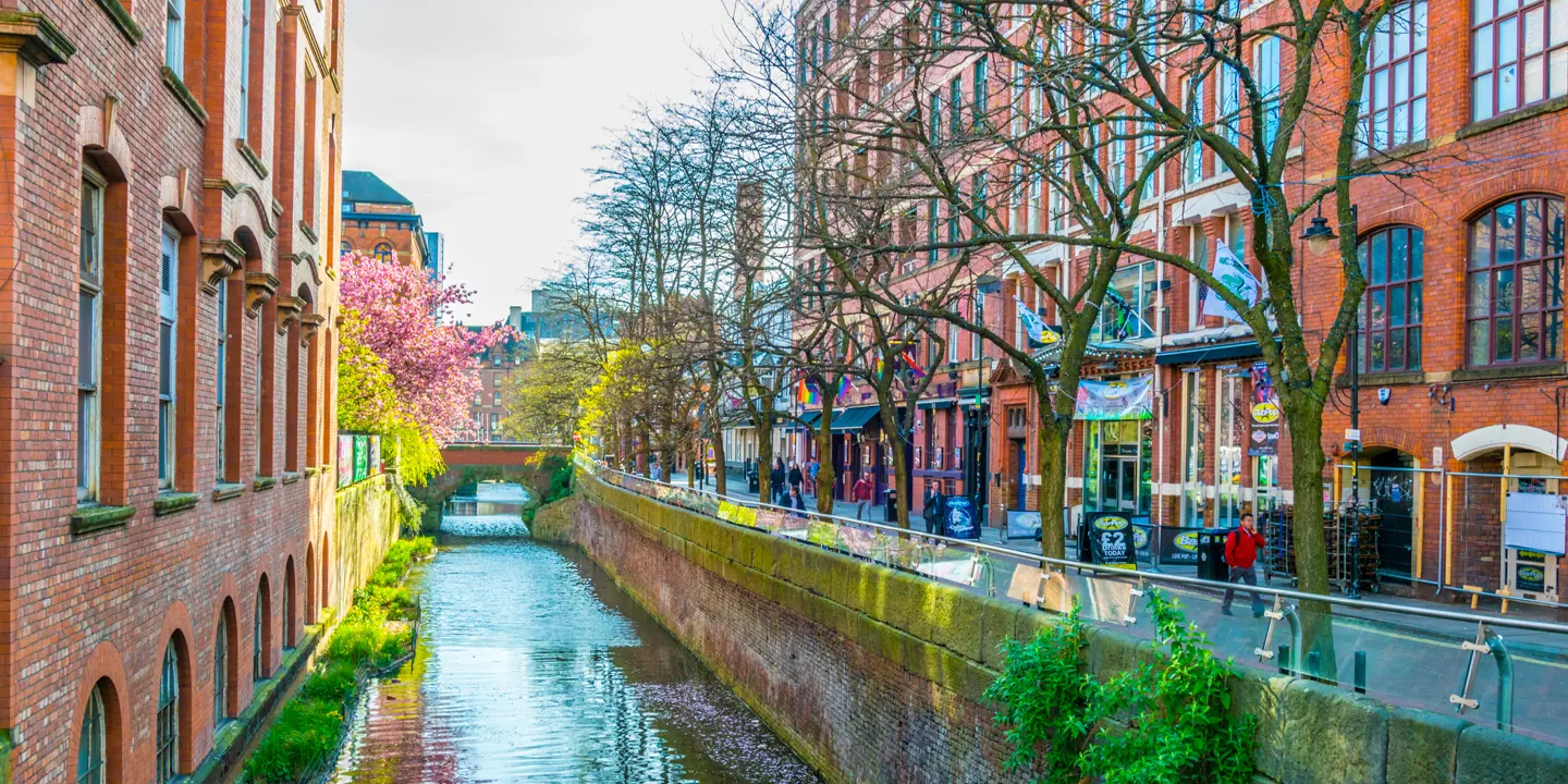 River flowing through urban landscape with towering buildings.