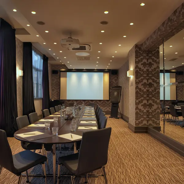 Conference room with projector screen and chairs.