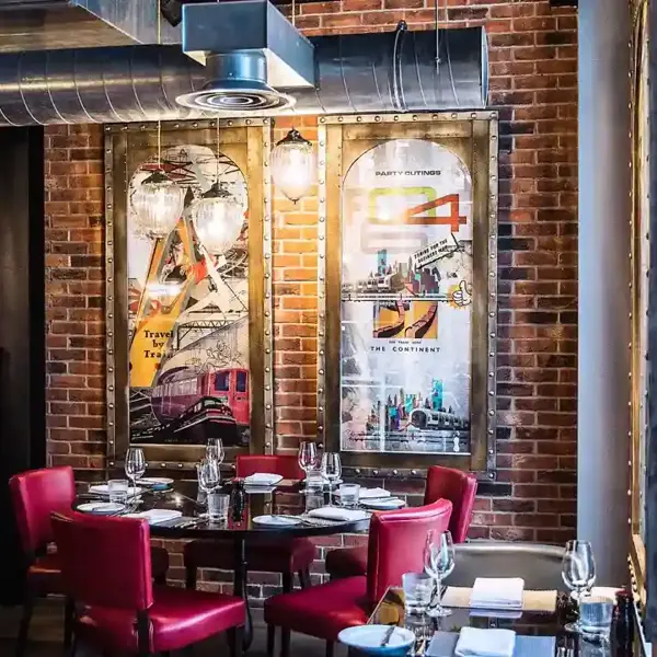 A restaurant featuring a brick wall backdrop and red booths.