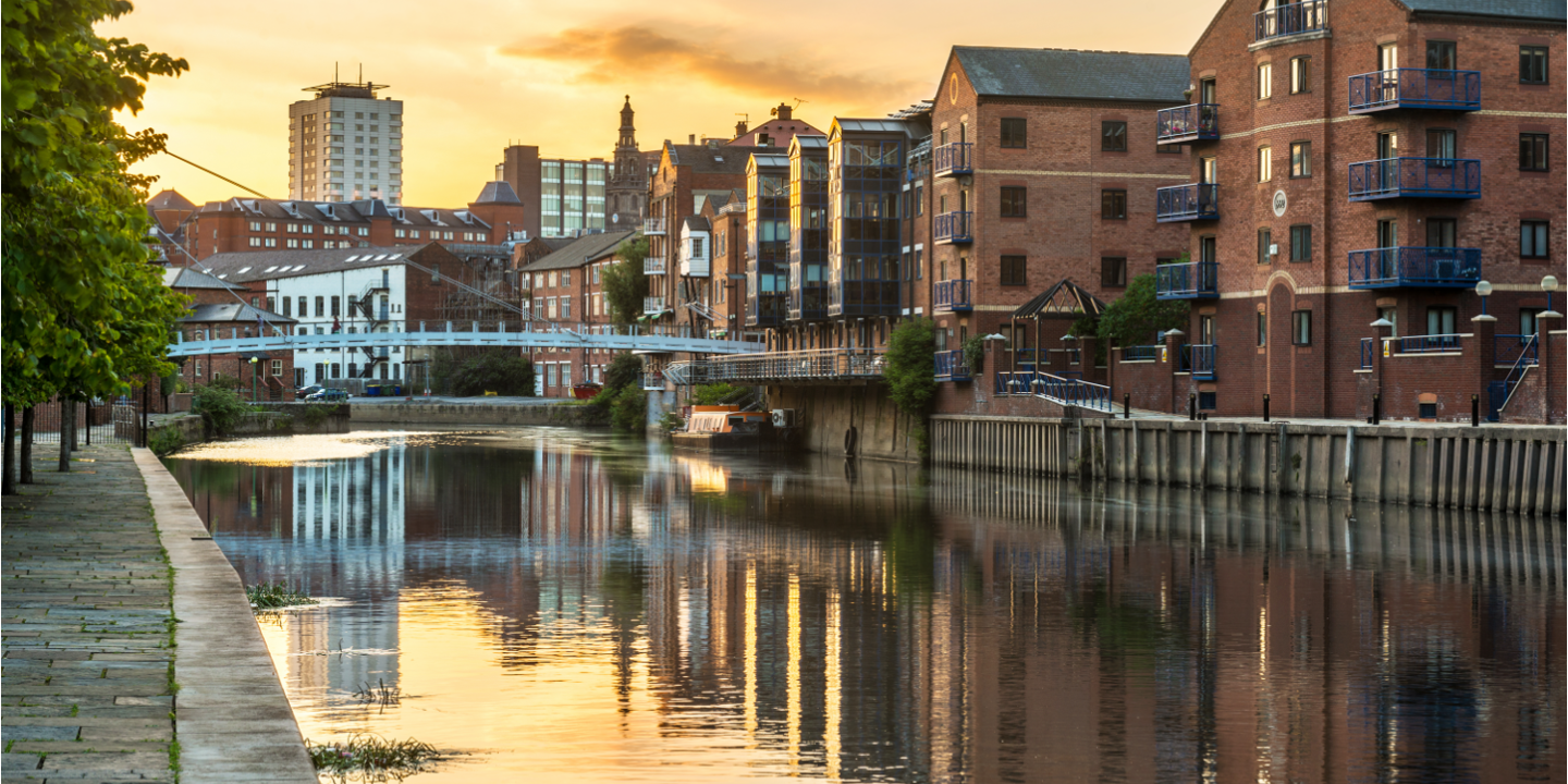 River flowing through urban landscape with towering buildings.