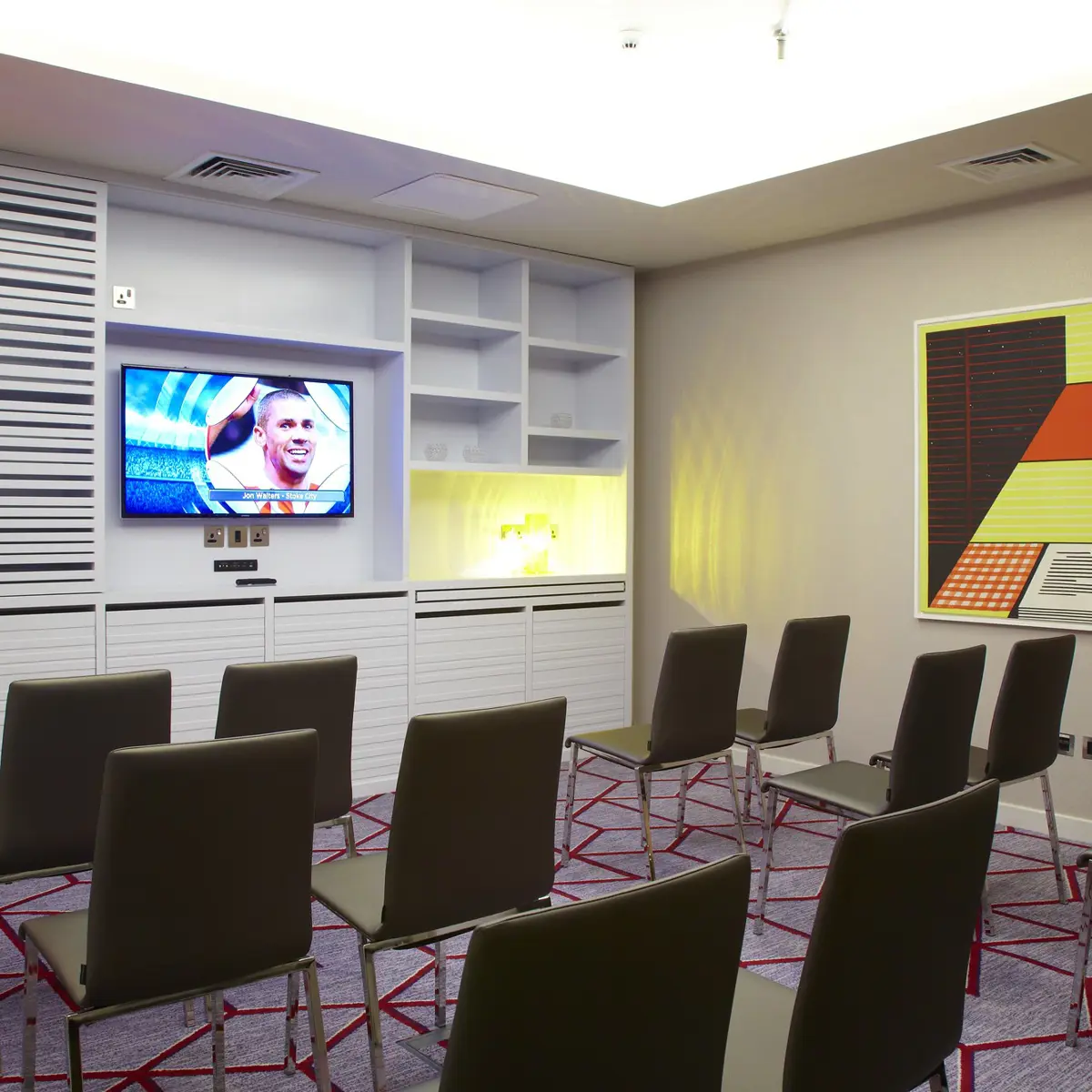 A room furnished with chairs and a flat-screen TV.