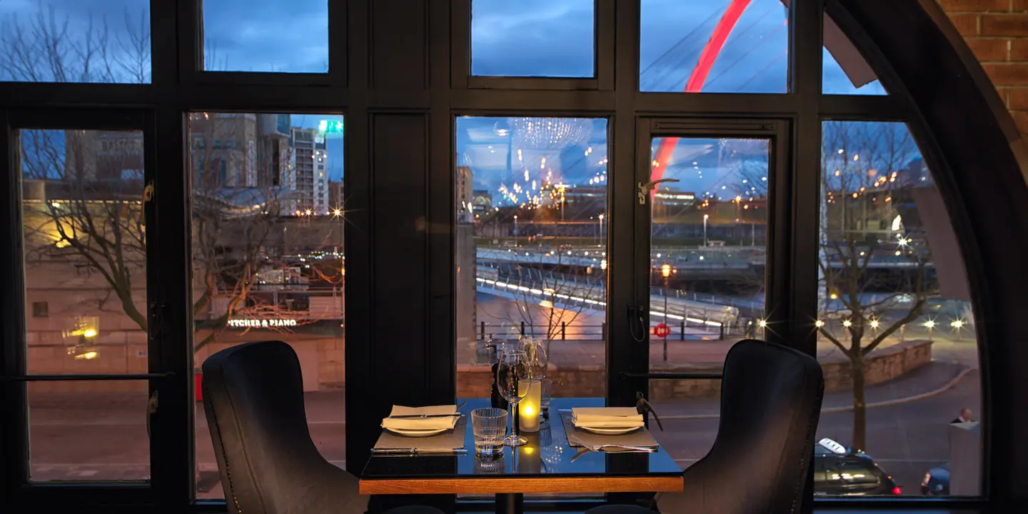 A dining table in front of a large window.