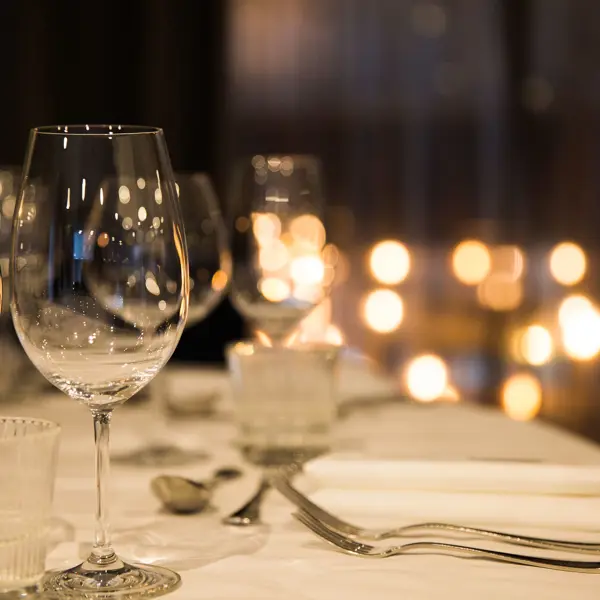 A beautifully arranged table adorned with elegant wine glasses and gleaming silverware.